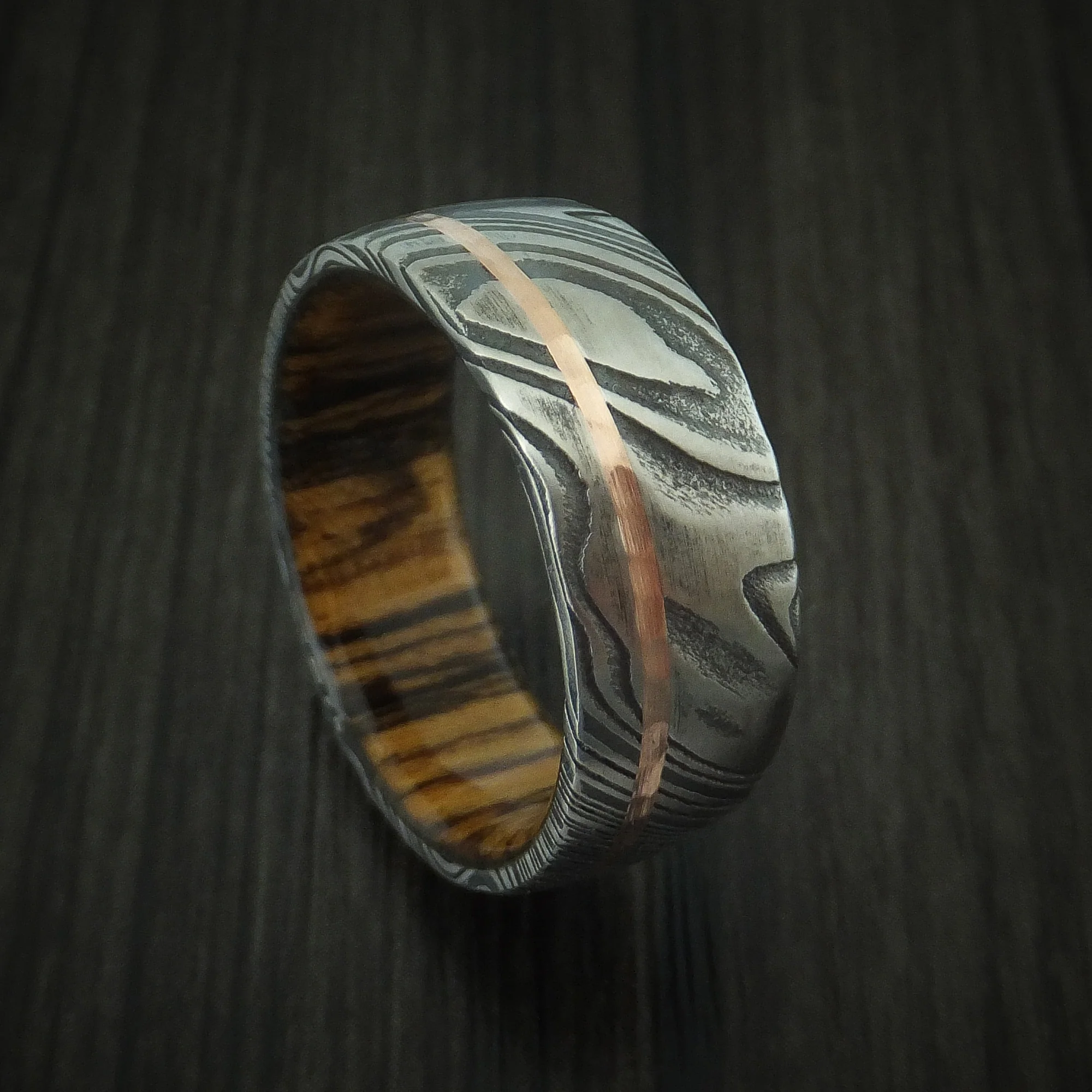Woodgrain Kuro Damascus Steel Men's Ring with 14K Rose Gold Inlay and Bocote Hardwood Sleeve Custom Made Wood Band